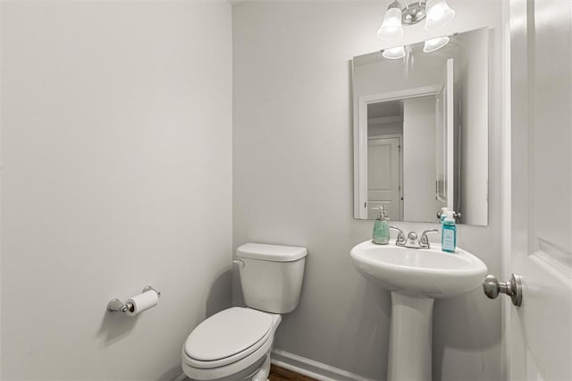 bathroom with baseboards and toilet