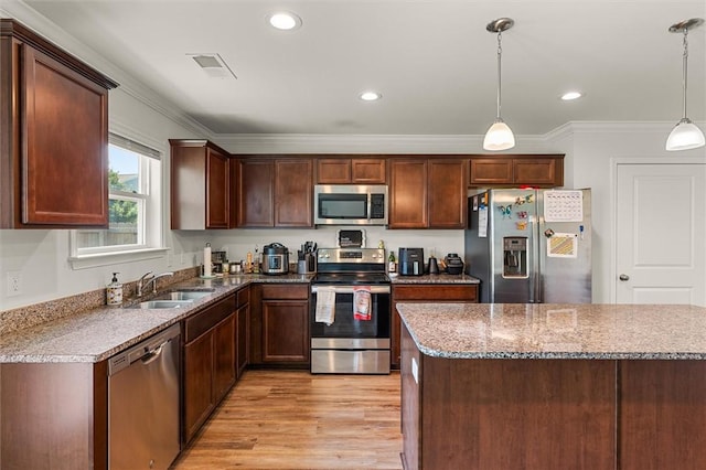 kitchen featuring crown molding, a sink, appliances with stainless steel finishes, visible vents, and light wood-type flooring