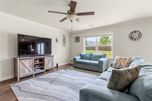 living area featuring wood finished floors, visible vents, ornamental molding, and baseboards