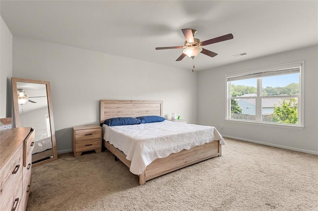 bedroom featuring baseboards, visible vents, light carpet, and ceiling fan