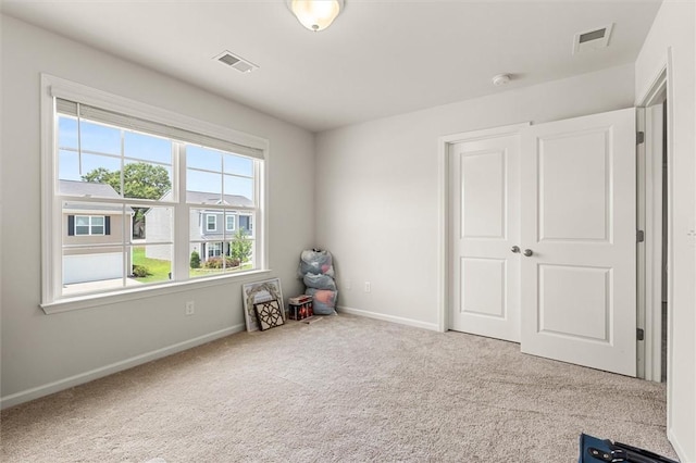 interior space with visible vents, carpet, and baseboards