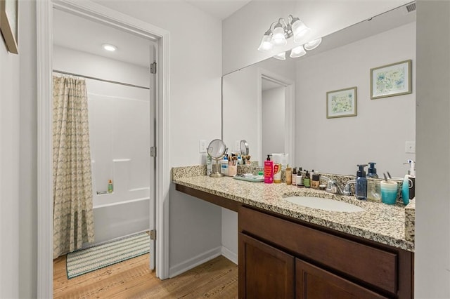 full bath with vanity, shower / tub combo with curtain, visible vents, and wood finished floors