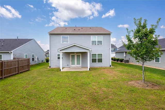 rear view of house featuring fence, a patio area, a yard, and central AC
