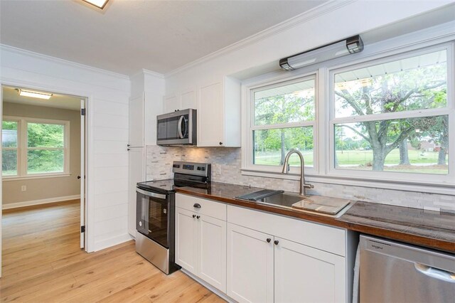4082 Old Portman Rd, Anderson, SC 29626 - kitchen featuring stainless steel appliances, light wood-style floors, ornamental molding, backsplash, and a sink