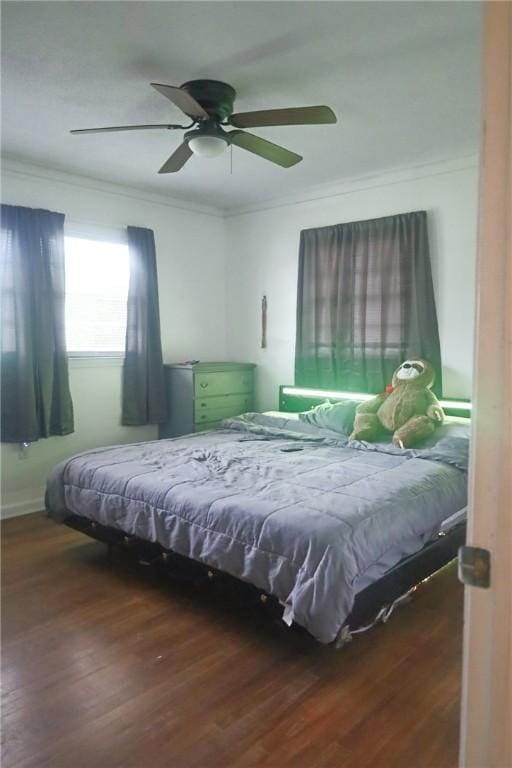 bedroom with wood finished floors, ceiling fan, and ornamental molding