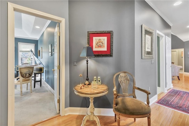 sitting room featuring ornamental molding, wood finished floors, and baseboards