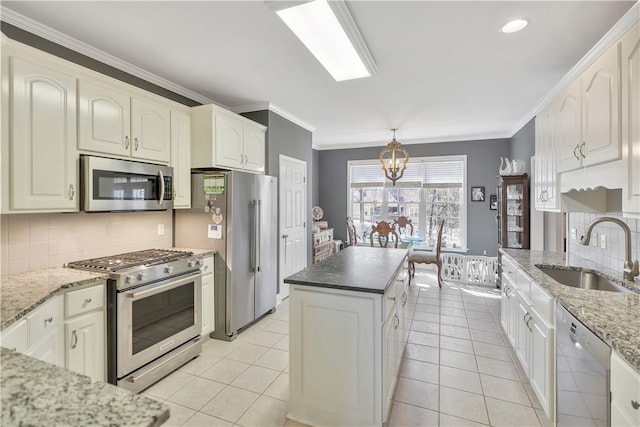 kitchen with an inviting chandelier, a sink, crown molding, backsplash, and appliances with stainless steel finishes