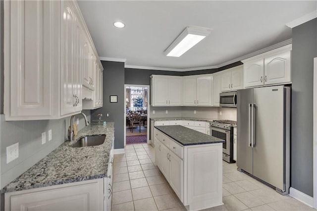 kitchen featuring light tile patterned floors, a sink, appliances with stainless steel finishes, and baseboards