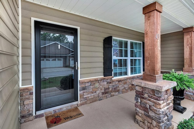 entrance to property with a porch and stone siding