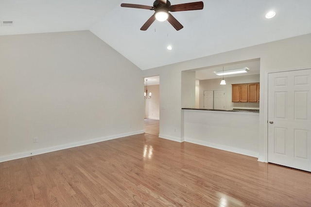 unfurnished living room with light wood-style flooring, ceiling fan with notable chandelier, recessed lighting, baseboards, and lofted ceiling