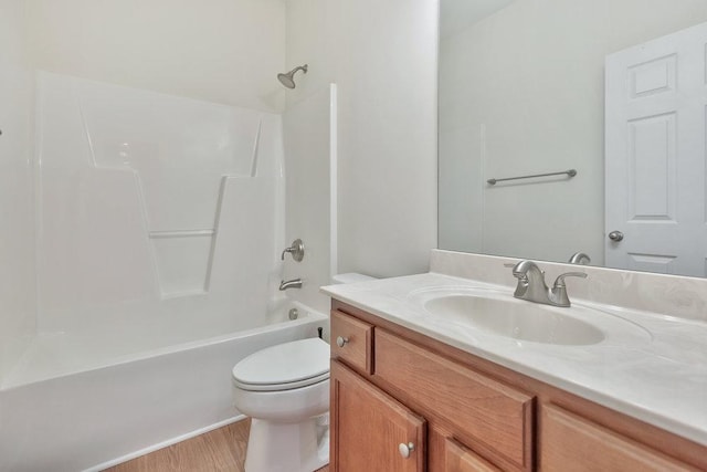 bathroom featuring wood finished floors, shower / bathtub combination, toilet, and vanity