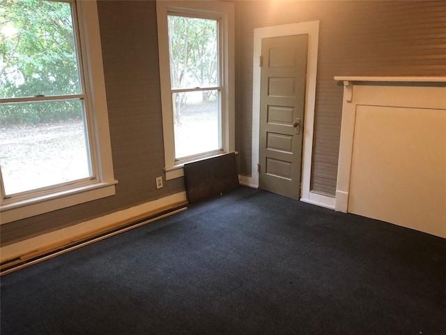 interior space with a wealth of natural light and dark colored carpet