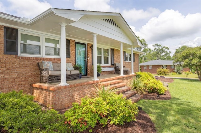 exterior space with a yard, a porch, and brick siding