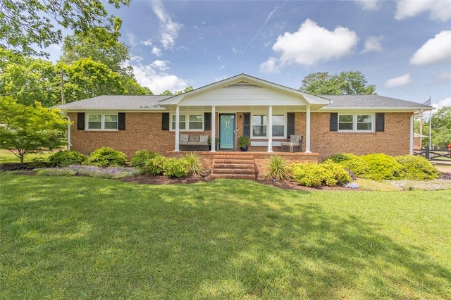ranch-style house featuring brick siding, a porch, and a front lawn