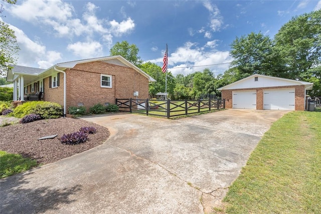 view of side of home featuring a gate, brick siding, fence, an outbuilding, and a garage