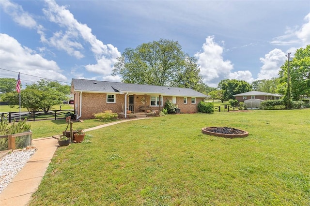 view of front of property with a front lawn, brick siding, and fence