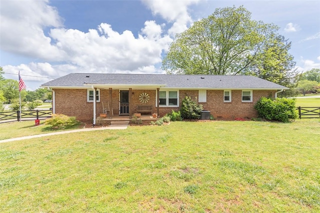 view of front of property with a porch, brick siding, fence, central AC, and a front lawn