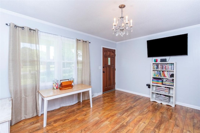 entrance foyer with a chandelier, baseboards, wood finished floors, and crown molding