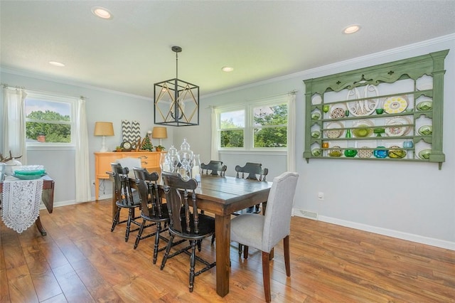 dining space featuring wood finished floors, visible vents, and crown molding