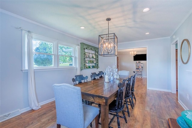 dining area featuring visible vents, baseboards, a notable chandelier, and wood-type flooring
