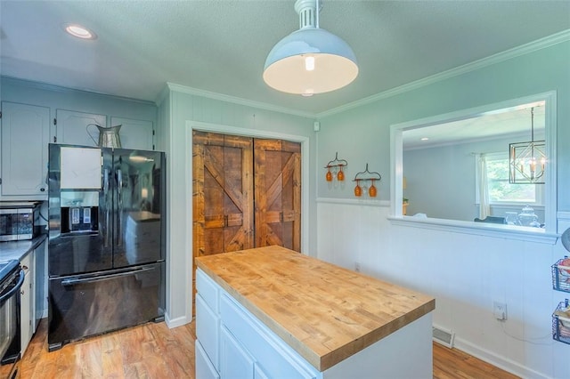 kitchen with visible vents, crown molding, black refrigerator with ice dispenser, and stainless steel microwave