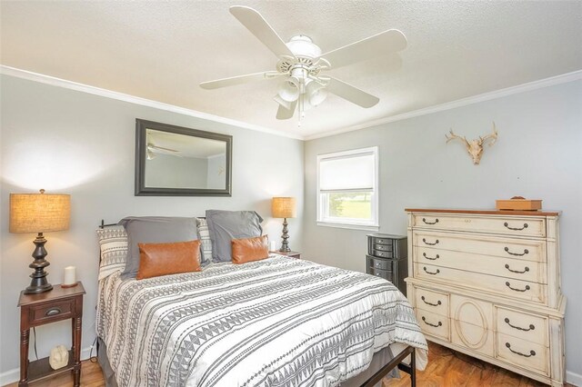 bedroom with baseboards, wood finished floors, a ceiling fan, and crown molding