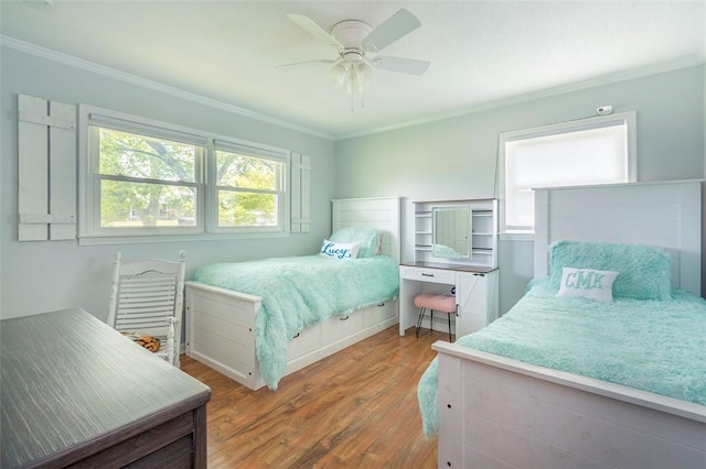 bedroom featuring crown molding, a ceiling fan, and wood finished floors