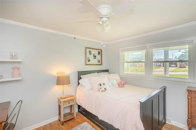 bedroom with light wood-style floors, crown molding, and baseboards