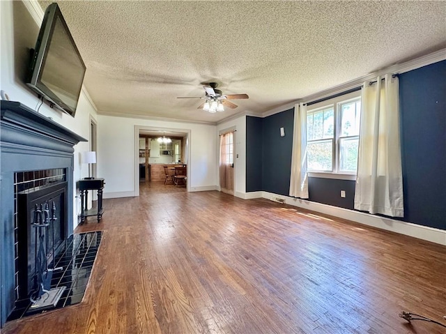 unfurnished living room with a textured ceiling, ceiling fan, wood finished floors, and ornamental molding