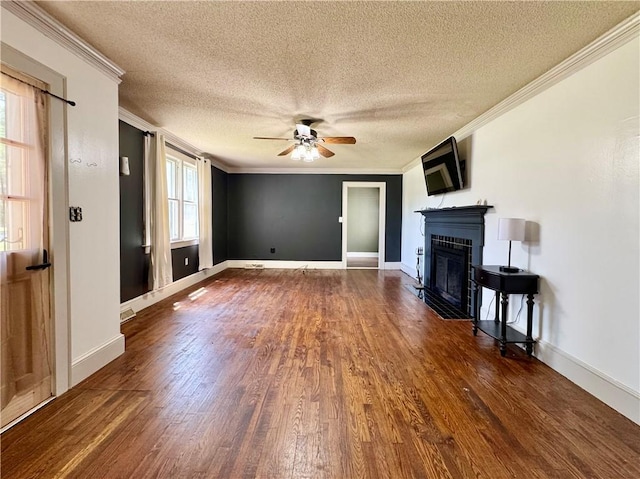 unfurnished living room with a fireplace with flush hearth, a textured ceiling, dark wood-style floors, ornamental molding, and a ceiling fan