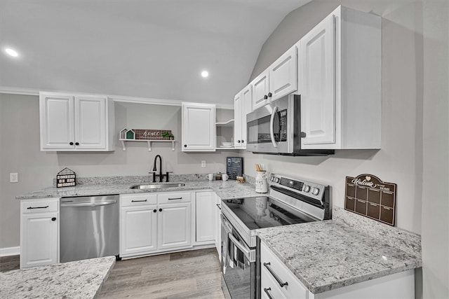 kitchen with a sink, stainless steel appliances, open shelves, light stone counters, and lofted ceiling