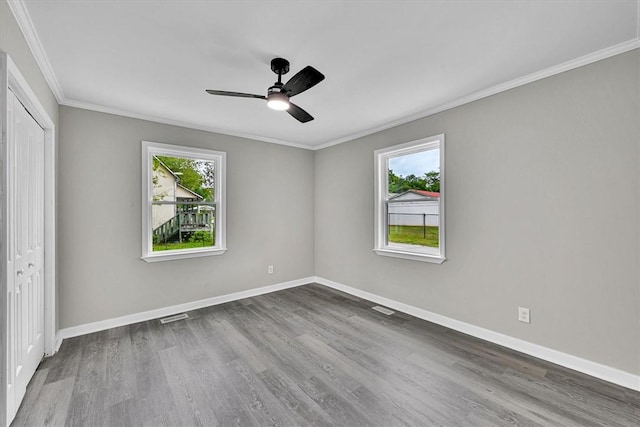 unfurnished room featuring baseboards, wood finished floors, and ornamental molding
