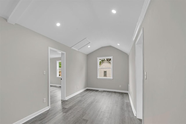unfurnished room featuring wood finished floors, a healthy amount of sunlight, and lofted ceiling