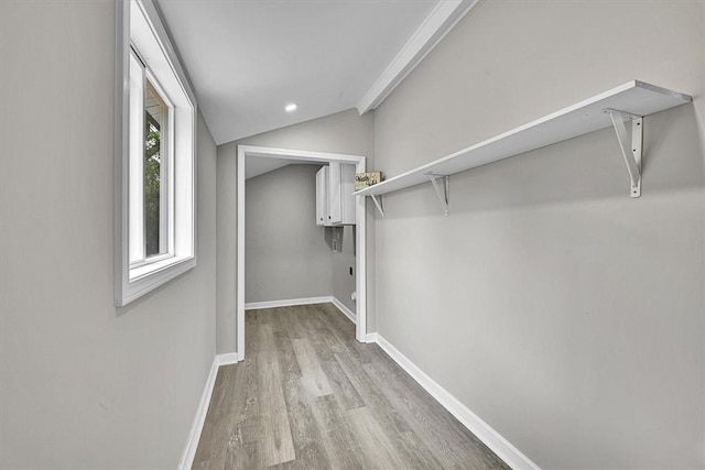 walk in closet with wood finished floors and lofted ceiling