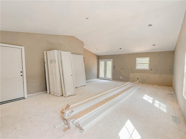 unfurnished room featuring french doors, baseboards, and lofted ceiling