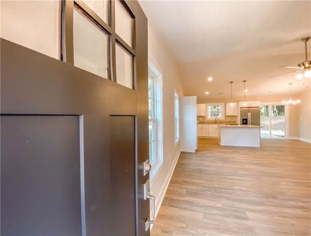 foyer featuring light wood-style floors, baseboards, and a ceiling fan