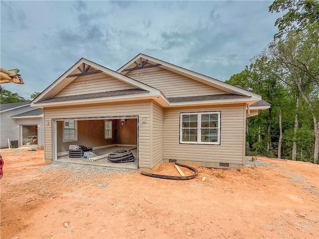 rear view of property featuring crawl space and a garage