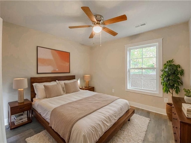 bedroom with visible vents, a ceiling fan, baseboards, and dark wood-style floors