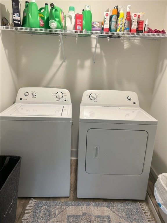 laundry area with washing machine and clothes dryer, laundry area, and wood finished floors