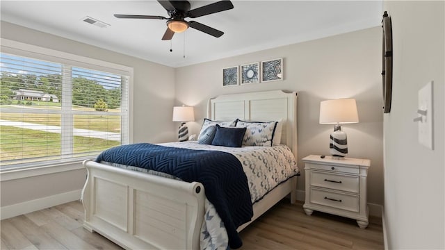 bedroom with a ceiling fan, baseboards, visible vents, and light wood-style floors