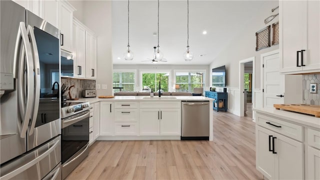 kitchen featuring light countertops, stainless steel appliances, tasteful backsplash, and light wood-type flooring