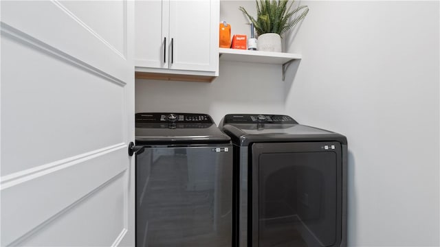laundry area with independent washer and dryer and cabinet space
