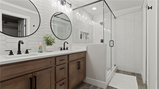 full bathroom featuring a sink, a shower stall, backsplash, and double vanity