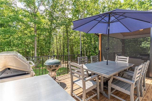 wooden deck with outdoor dining space and a grill