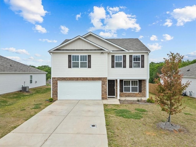 traditional home with an attached garage, concrete driveway, a front yard, and stone siding