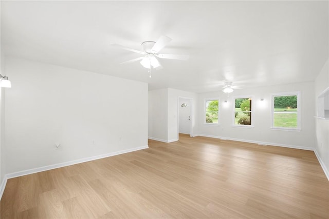spare room featuring baseboards, a ceiling fan, and light wood-type flooring