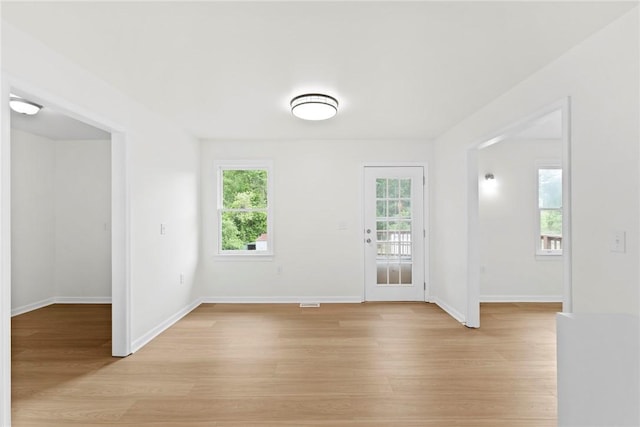 spare room with baseboards and light wood-style flooring