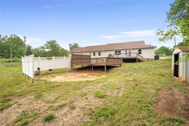 rear view of property featuring a yard, crawl space, fence, and a wooden deck