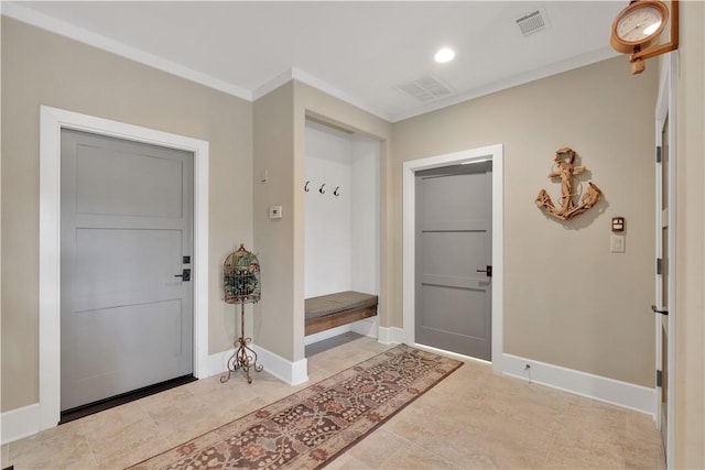 foyer with visible vents, ornamental molding, and baseboards