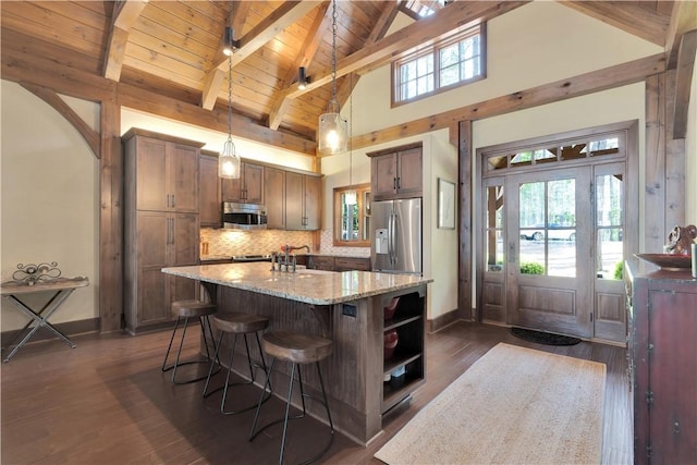 kitchen featuring wood ceiling, light stone countertops, baseboards, a breakfast bar, and stainless steel appliances